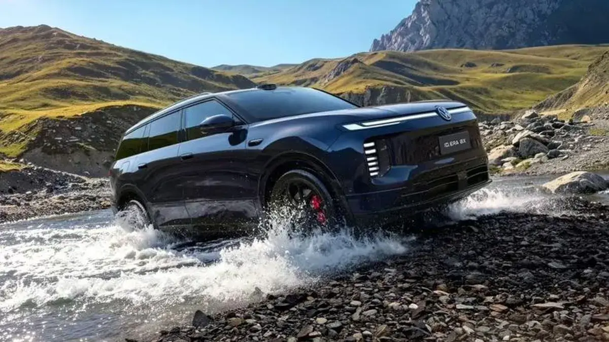 Гибридный кроссовер Volkswagen ID. Era 8X на фоне живописного горного пейзажа во время преодоления брода.